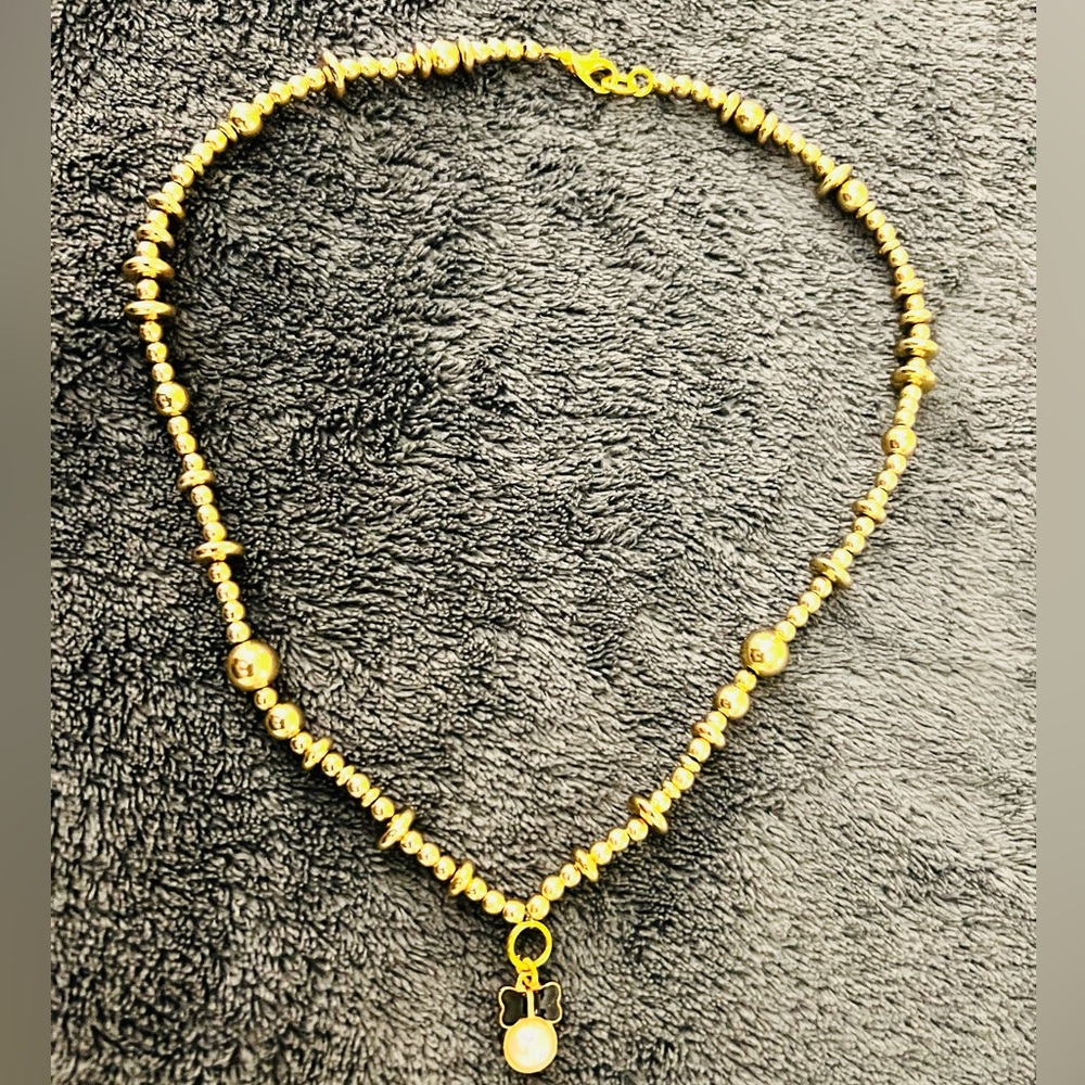 Gold beaded butterfly pendant necklace.